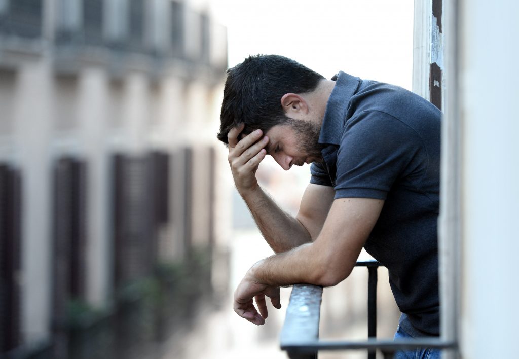 Lonely Young Man Outside At House Balcony Looking Depressed