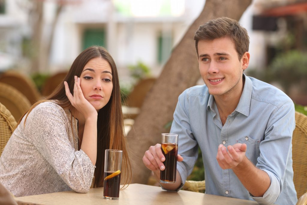 Man And Woman Dating In A Restaurant Terrace But She Is Bored