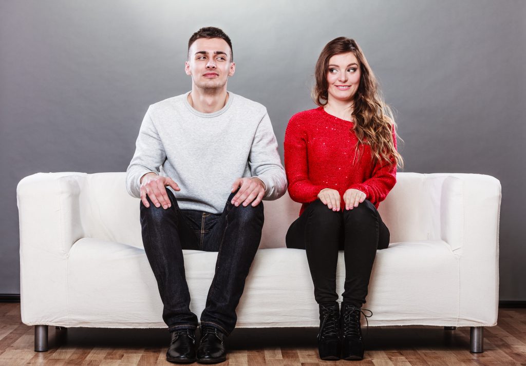 Shy Woman And Man Sitting On Sofa