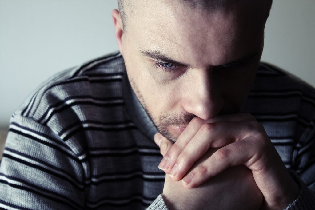 Young Man Sitting Looking Upset